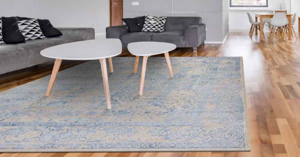 Ein blauer Teppich im Wohnzimmer unter einem Tisch aus der Kauria Collection