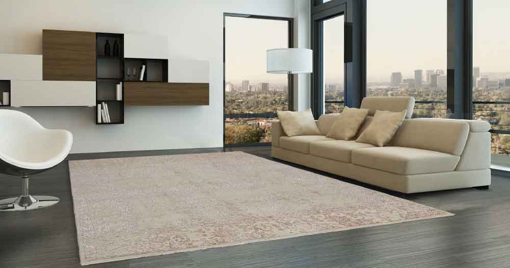 Ein beiger Teppich im Wohnzimmer neben einem Sofa aus der Kauria Collection